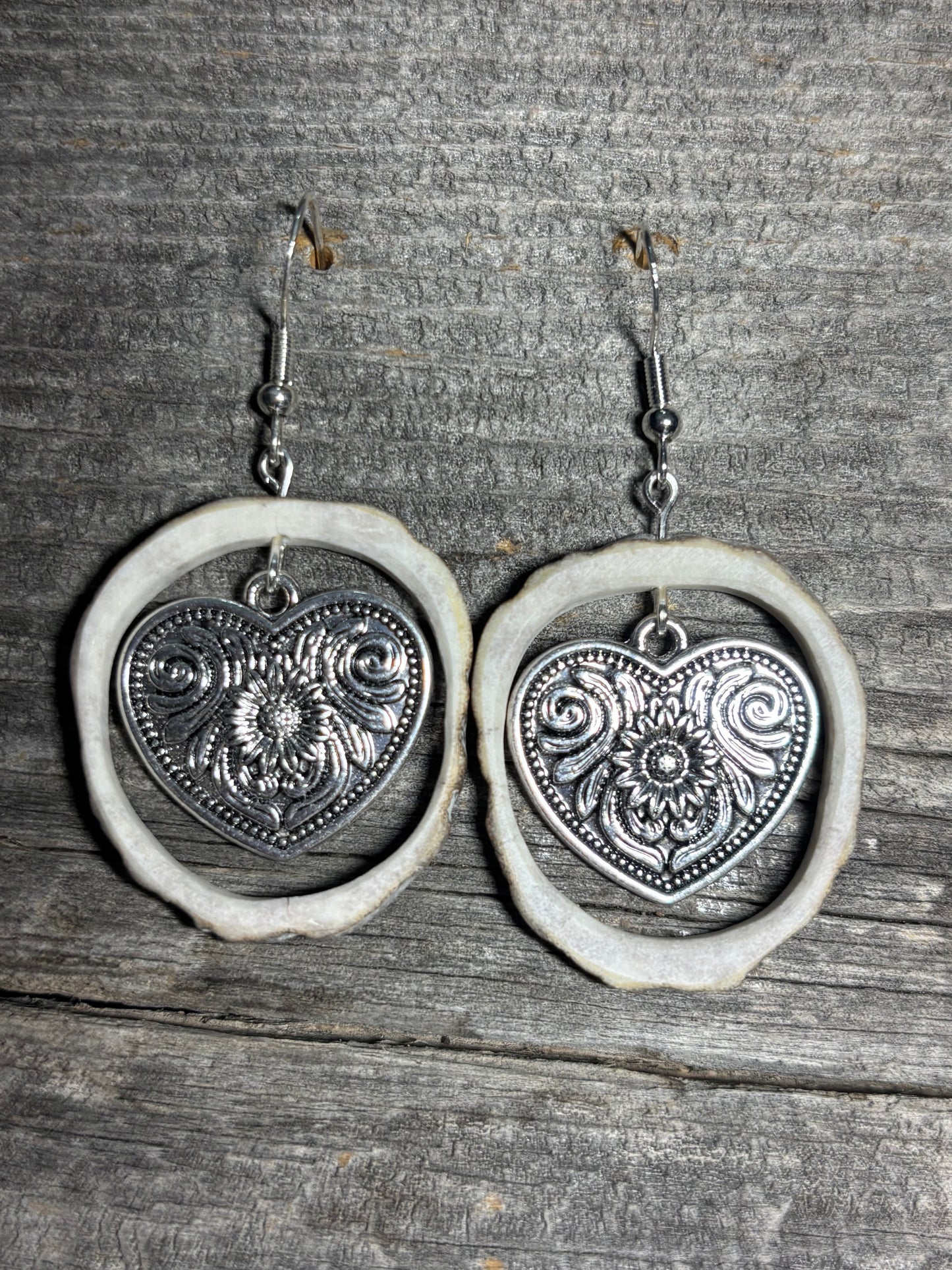 Silver heart shaped charm with flower design
